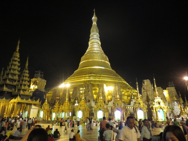 Kết quả hình ảnh cho Chùa Vàng ở Yangon là ngôi chùa linh thiêng bậc nhất ở Myanmar. Tương truyền rằng nơi đây có lưu giữ 4 báu vật của Phật giáo là: Cây gậy của Phật Câu Lưu Tôn, mảnh áo của Phật Ca Diếp, lọc nước của Phật Câu Na Hàm và 8 sợi tóc của Phật Thích Ca Mâu Ni. Không chỉ cổ kính thiêng liêng mà nơi đây còn là điểm du lịch đẹp nổi tiếng ở Myanmar bởi lối kiến trúc vô cùng độc đáo và bắt mắt. Cổng vào chùa Vàng Myanmar với cặp Tỳ Hưu khổng lồ cao 9m ở hai bên Chùa có toàn bộ hệ thống nội thất được trạm trổ vô cùng cầu kỳ và tỷ mỷ với 8.690 lá vàng dát cực mỏng, toàn bộ ngôi chùa được điểm tô thêm phần lung linh ảo diệu với 5.450 viên kim cương đủ kích cỡ và 2.320 viên hồng ngọc, lam ngọc. Ngôi chùa biểu tượng của sự linh thiêng đất nước Myanmar này sẽ làm bạn vô cùng thích thú bởi màu sắc của nó biến hoa đa dạng tùy vào từng thời điểm trong ngày.